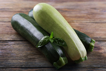 Fresh zucchini with squash and basil on wooden table close up
