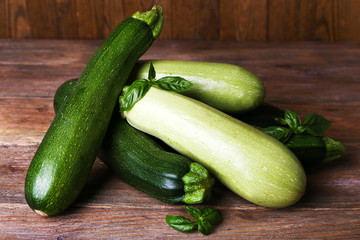 Fresh zucchini with squash and basil on wooden table close up