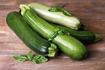 Fresh zucchini with squash and basil on wooden table close up