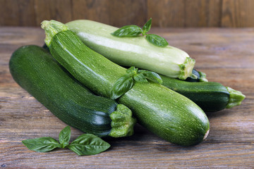 Fresh zucchini with squash and basil on wooden table close up