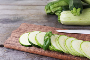 Fresh zucchini with squash and basil on wooden table close up