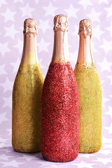 Bright bottles of champagne on paper background