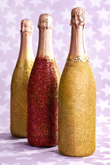 Bright bottles of champagne on paper background