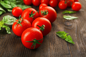 Fresh tomatoes with basil on wooden background