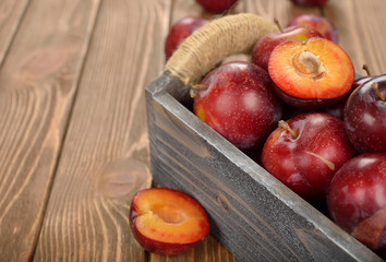 Naklejka na ściany i meble Fresh plums in a wooden box