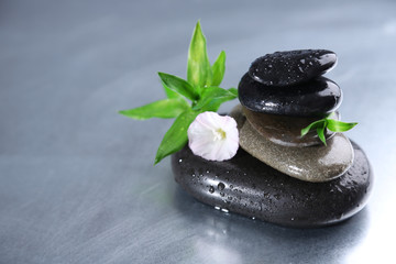 Stack of spa stones with green leaves and flower