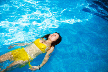 portrait of a young woman relaxing in a swimming pool. swim 