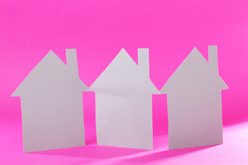 Color paper houses on pink background