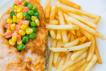 Grilled salmon steak meal served with salad and French fries