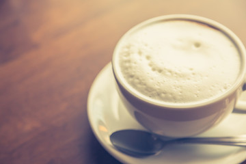 Hot latte art coffee on table ( Filtered image processed vintage