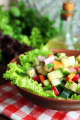 Wooden bowl of fresh vegetable salad on napkin, closeup