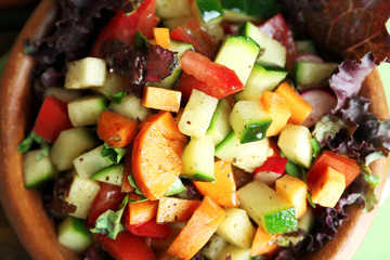 Wooden bowl of fresh vegetable salad, closeup