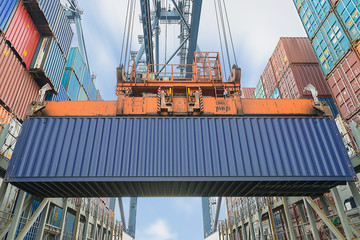 Shore crane loading containers in freight ship