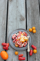 Just prepared tomato and onion salad on a tin plate.