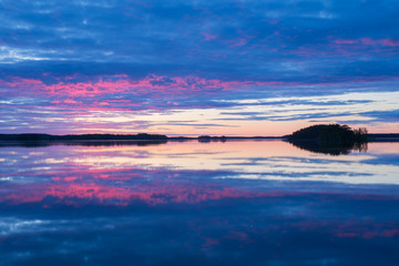 Midnight light over calm lake in north of Sweden