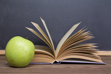 books and apple slate background