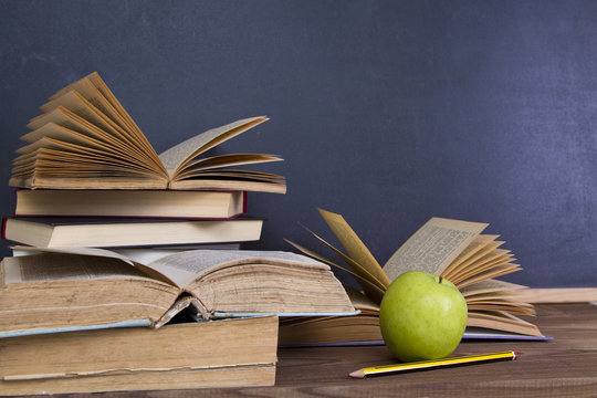 books and apple slate background
