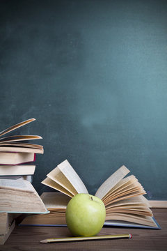 books and apple slate background