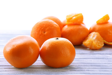 Ripe tangerines on wooden table isolated on white