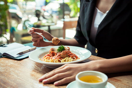 close up of woman eating spaghetti meatball