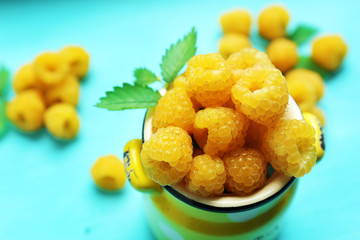 Yellow raspberries on turquoise table, closeup