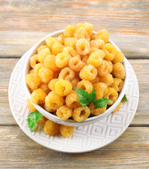 Yellow raspberries in bowl on wooden background