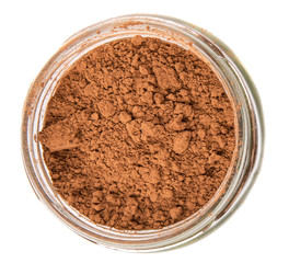 Obraz na płótnie Canvas Brown pure cocoa powder in a mason jar over white background