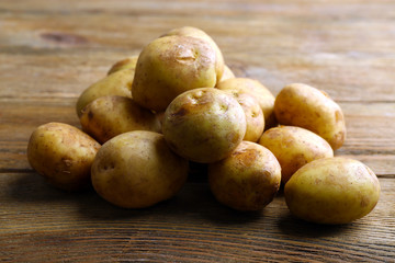 Young potatoes on wooden table close up