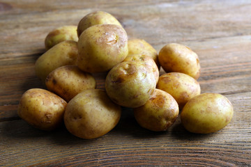 Young potatoes on wooden table close up
