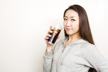 アイスコーヒーのグラスを持つパーカーの女性