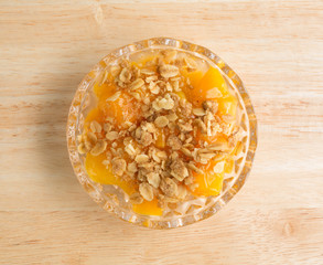 Bowl of peaches with brown sugar and oats on counter top