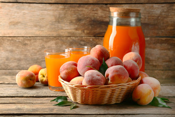 Ripe peaches and juice on wooden background