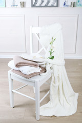 Fototapeta na wymiar Bath set with white bathrobe on chair, indoors