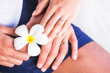 hands with wedding ring and Frangipani flowers or Plumeria