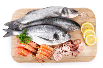 Seafood collection on wooden cutting board isolated on white