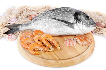 Fresh dorado fish and shrimps on wooden cutting board, closeup