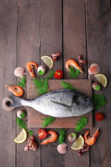 Dorado fish and other ingredients on wooden table, top view