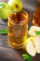 Glasses of apple juice on wooden table, closeup