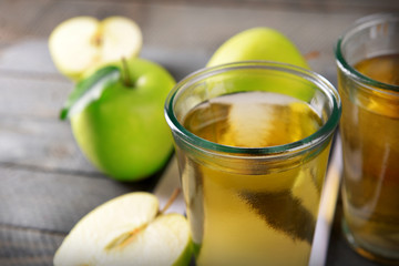 Glasses of apple juice on wooden table, closeup