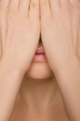 Fototapeta premium woman's face covered by two hands