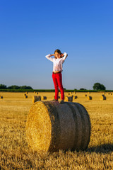 Naklejka na ściany i meble Teenage girl with long hair posing in summer field, countryside
