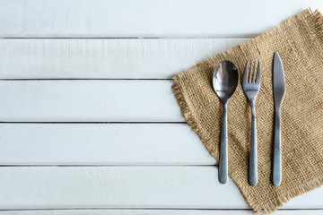wooden spoon and fork with dish on white wooden table