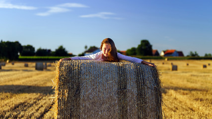 Teenage girl with long hair posing in summer field, countryside