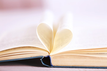 Pages of book curved into heart shape, close up