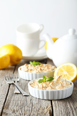 Lemon meringue pie in bowl on grey wooden background