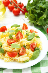 Delicious pasta on plate on white wooden background