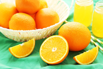 Ripe oranges in basket on green background