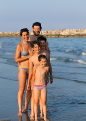 family of five people during the summer holidays on the beach