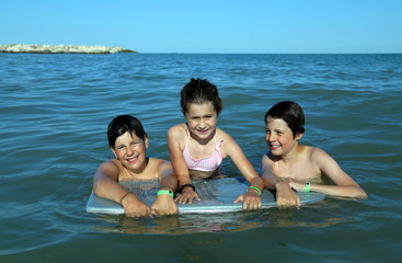 Obraz premium three young brothers have fun playing in the sea in summer