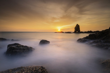 Fototapeta premium Sea wave hit the rock at sunset in Thailand